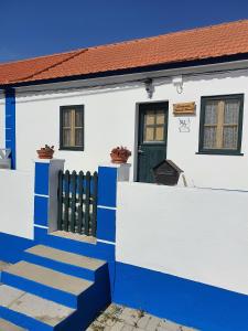 biało-niebieski dom z zielonymi drzwiami w obiekcie Comporta Family House w mieście Comporta