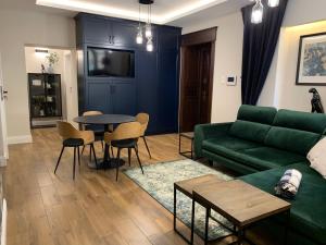 a living room with a green couch and a table at Apartament Ratuszowy in Zamość