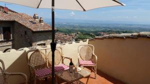 a balcony with two chairs and an umbrella at The Roof House in Montepulciano