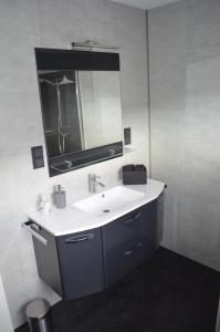 a bathroom with a white sink and a mirror at Ferienwohnung Stambach in Contwig +28 photos