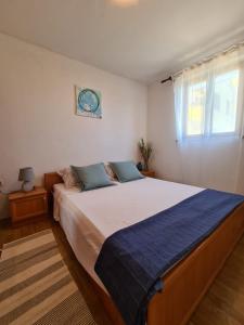 una camera da letto con un letto grande e una finestra di Apartment Sofia a Mali Lošinj (Lussinpiccolo)