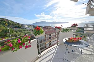 a balcony with a table and flowers on it at SunRise Suites in Vlorë