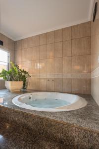 a large tub in a bathroom with a tile wall at Drops Motel São José do Rio Preto in Sao Jose do Rio Preto +35 photos