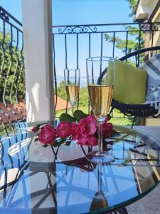 dos copas de champán y rosas en una mesa de cristal en Apartment Luce, en Pićan