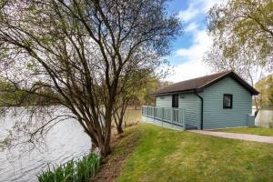 a blue building next to a body of water at The Vale Golf & Country Club in Bishampton