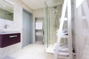 - Baño con ducha, lavabo y escalera en The Vale Golf & Country Club en Bishampton