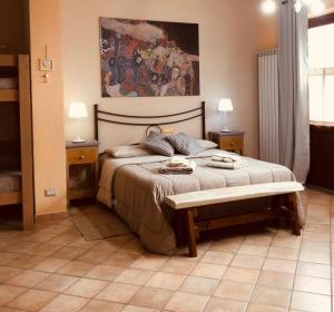 a bedroom with a bed with a bench and a painting at B&B La Lumachella in Porano