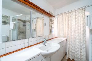 a white bathroom with a sink and a mirror at Apartments Martecchini in Dubrovnik +46 photos