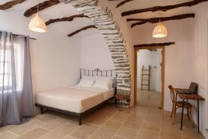 a bedroom with a bed and a ceiling with beams at Irida house in Amorgos