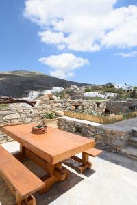 una mesa de picnic de madera en la parte superior de una pared de piedra en Irida house, en Amorgós