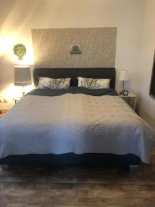 a large bed in a bedroom with two lamps at Ferienwohnung Am Haineberg in Porta Westfalica