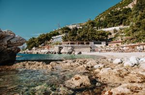 a beach with a group of people in the water at Inn Hotel in Vlorë