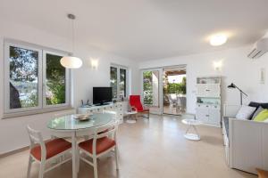 una sala de estar blanca con mesa y sillas en Villa Ida, en Milna