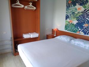 ein Schlafzimmer mit einem weißen Bett und einer Blumenwand in der Unterkunft Ada Neptuno Apartamento, Aire acondicionado, WiFi, Piscinas, Parking in Peñíscola + 29 Fotos