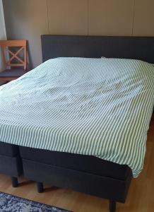 a bed with a blue and white comforter on it at 't uiltje in Ermelo