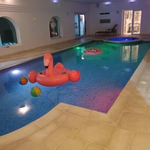 una piscina cubierta con un juguete inflable en el agua en Country Manor House with indoor pool and hot tub, en Rochester
