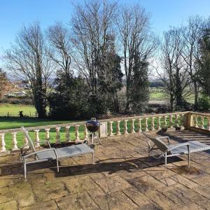 two chairs and a vase sitting next to a fence at Historic Manor House - Sleeps 16 - Pool & Hot Tub in Rochester
