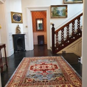a hallway with a rug on the floor and a staircase at Historic Manor House - Sleeps 16 - Pool & Hot Tub in Rochester