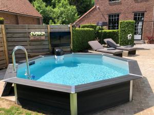 - un bain à remous avec un lavabo dans la cour dans l'établissement B&B Le Pavillon Du Bois De Buis, à Thorembais-Saint-Trond