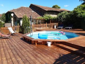 a hot tub on a wooden deck with a wooden deck at Le Figuier in Le Lindois