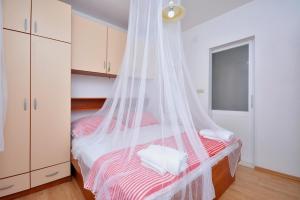 a bedroom with a bed with a mosquito net at Apartment with large terrace 3558-4 in Žuljana