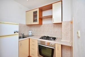 a small kitchen with a stove and a sink at Apartment with large terrace 3558-4 in Žuljana