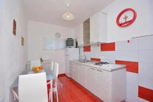 a kitchen with white appliances and red and white walls at One bedroom apartment 3558-5 in Žuljana