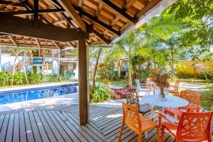un patio con tavolo e sedie accanto alla piscina di Pouso do Grego a Ilhabela