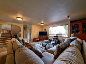 a living room with a large couch and a television at La Casa Rosa in Ensenada