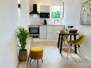 a kitchen with a table and chairs in a room at Duplex Bellevue SPA PRIVATIF Toit d'Aix in Aix-en-Provence