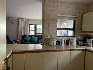 Kitchen o kitchenette sa Jackie’s 3 bedroomed secure beach front apartment Strand Golden Mile 