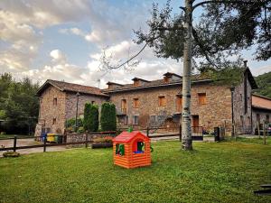 an orange play house in the grass in front of a building at Casa rural Quintana - Montanuy in Montanúy