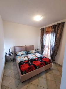 um quarto com uma cama com rosas vermelhas em Vivere in famiglia em Orosei