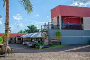 un edificio con una palma accanto a un parcheggio di Hotel Della Vita a Glória de Dourados