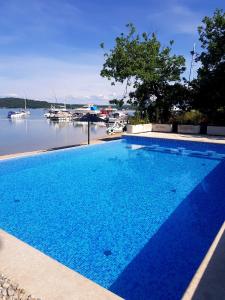 a large blue swimming pool next to a body of water at Krk Mobile Homes in Klimno