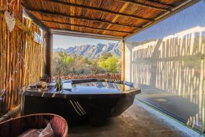 d'une baignoire avec vue sur la montagne. dans l'établissement Steenbok farm cottages Aalwyn Cottage, à Wolseley