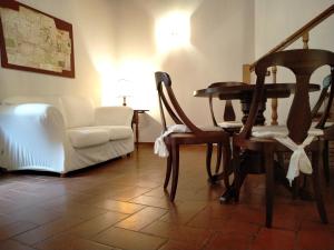 un soggiorno con tavolo, sedie e divano di Small lovely home in Pienza a Pienza