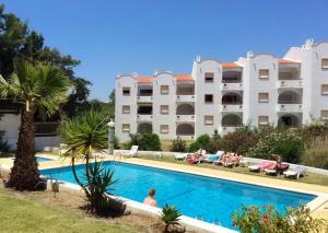 um hotel com piscina em frente a um edifício em Casa Nikolina em Albufeira