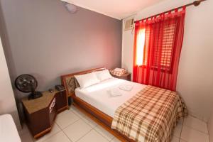 a bedroom with a bed and a red window at Hotel Cambará - By UP Hotel in Osasco