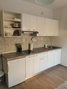 a kitchen with white cabinets and a counter top at Apartmani Kronjac in Milna +38 photos