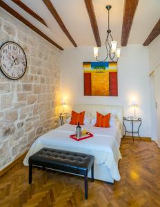 a bedroom with a large bed with a clock on the wall at Kanavelic place - Old town Korcula in Korčula