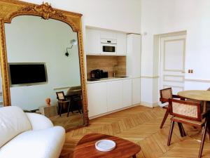 een woonkamer met een spiegel en een tafel bij Appartement de standing 2 - tour Eiffel/Invalides in Parijs