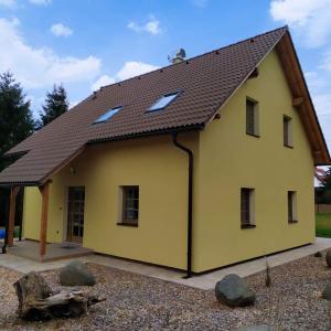 een geel huis met een bruin dak bij Loučná in Hrádek nad Nisou