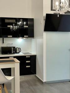 uma cozinha com armários a preto e branco e um micro-ondas em Luxury studio em Zadar