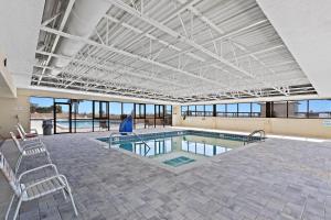a large swimming pool with chairs and a large ceiling at SunDestin Resort Unit 0814 in Destin