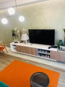 sala de estar con TV de pantalla plana en un centro de entretenimiento en Apartament Moniuszko z Parkingiem podziemnym en Gorzów Wielkopolski