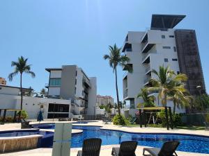 una piscina con sillas frente a un edificio en Manzara Resort, en Mazatlán