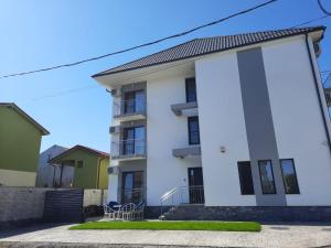 ein weißes Wohnhaus mit grünen und gelben in der Unterkunft Vila Allure in Eforie Nord