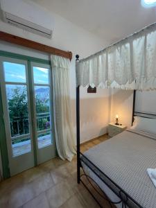 a bedroom with a bed and a large window at Patmos Villas in Grikos
