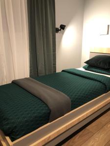 un letto con piumone verde in una camera da letto di Club Robert Motel a Hîrşova